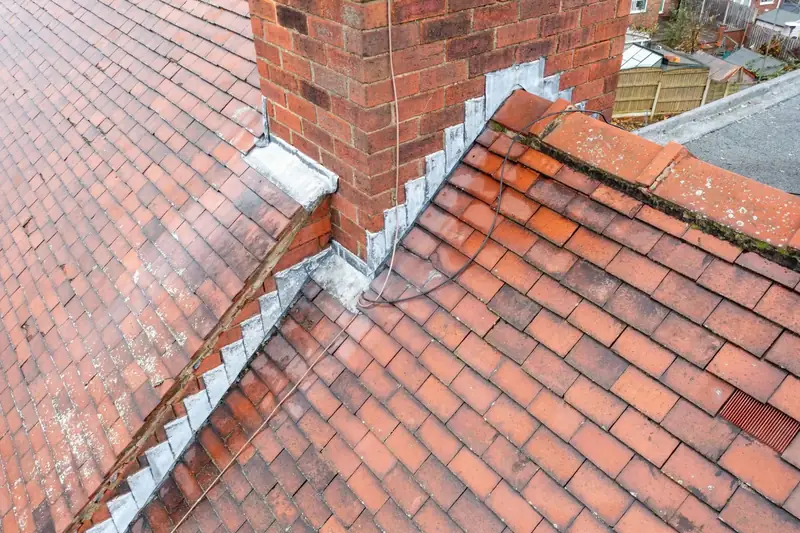 Stepped lead flashing where a brick chimney meets a clay tiled roof